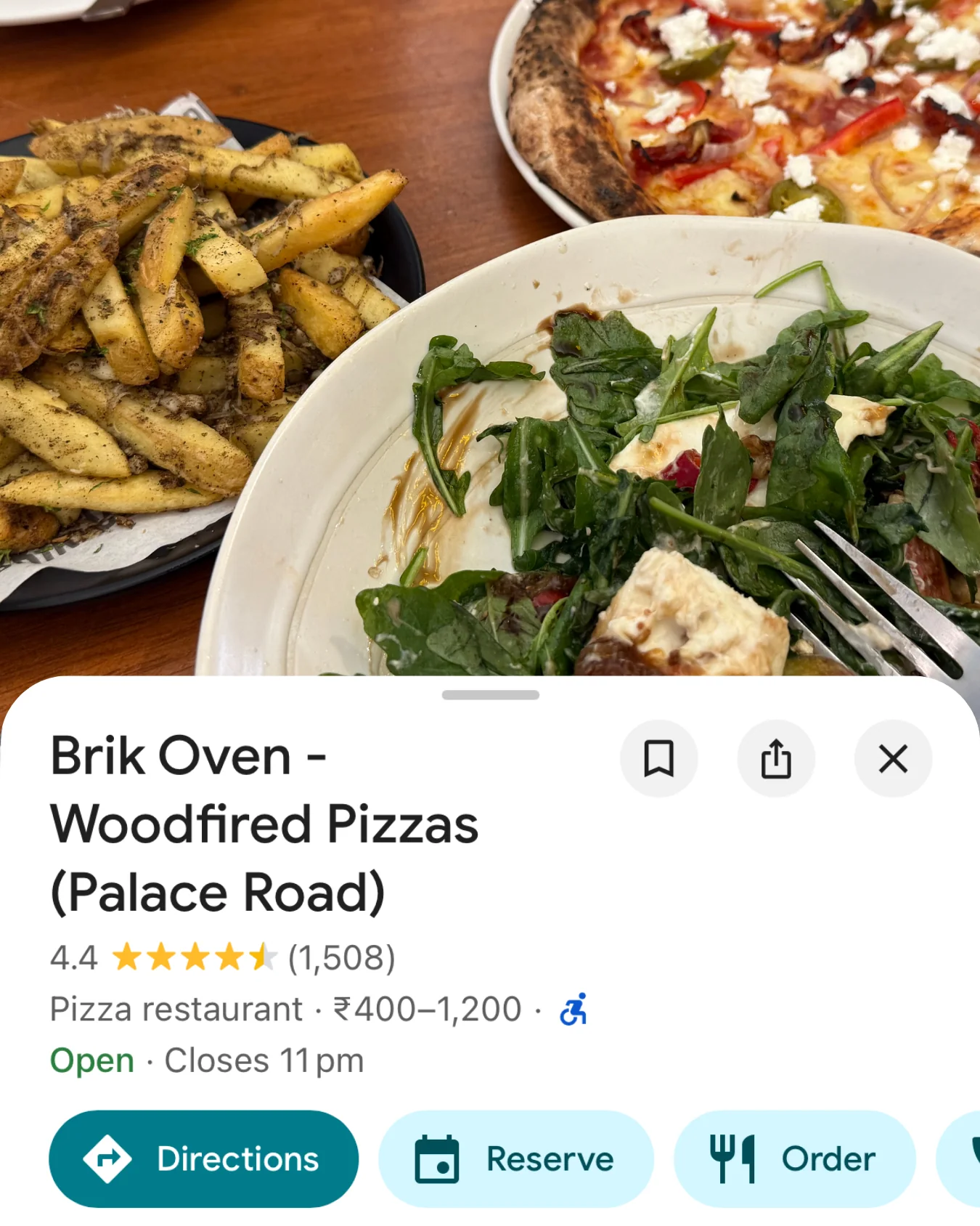Card for Brik Oven on Palace Road, Bengaluru — a woodfired pizza, fries and burrata salad.