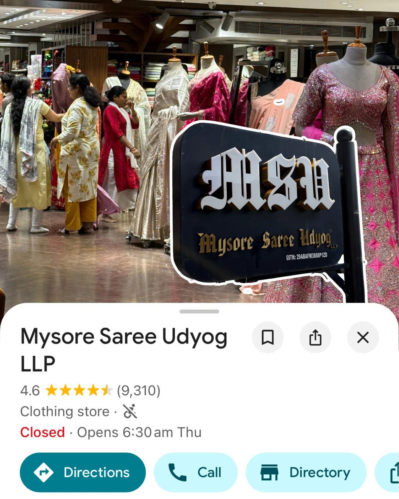Card for Mysore Saree Udyog LLP in Bengaluru — the shopfront sign amid racks of sarees.